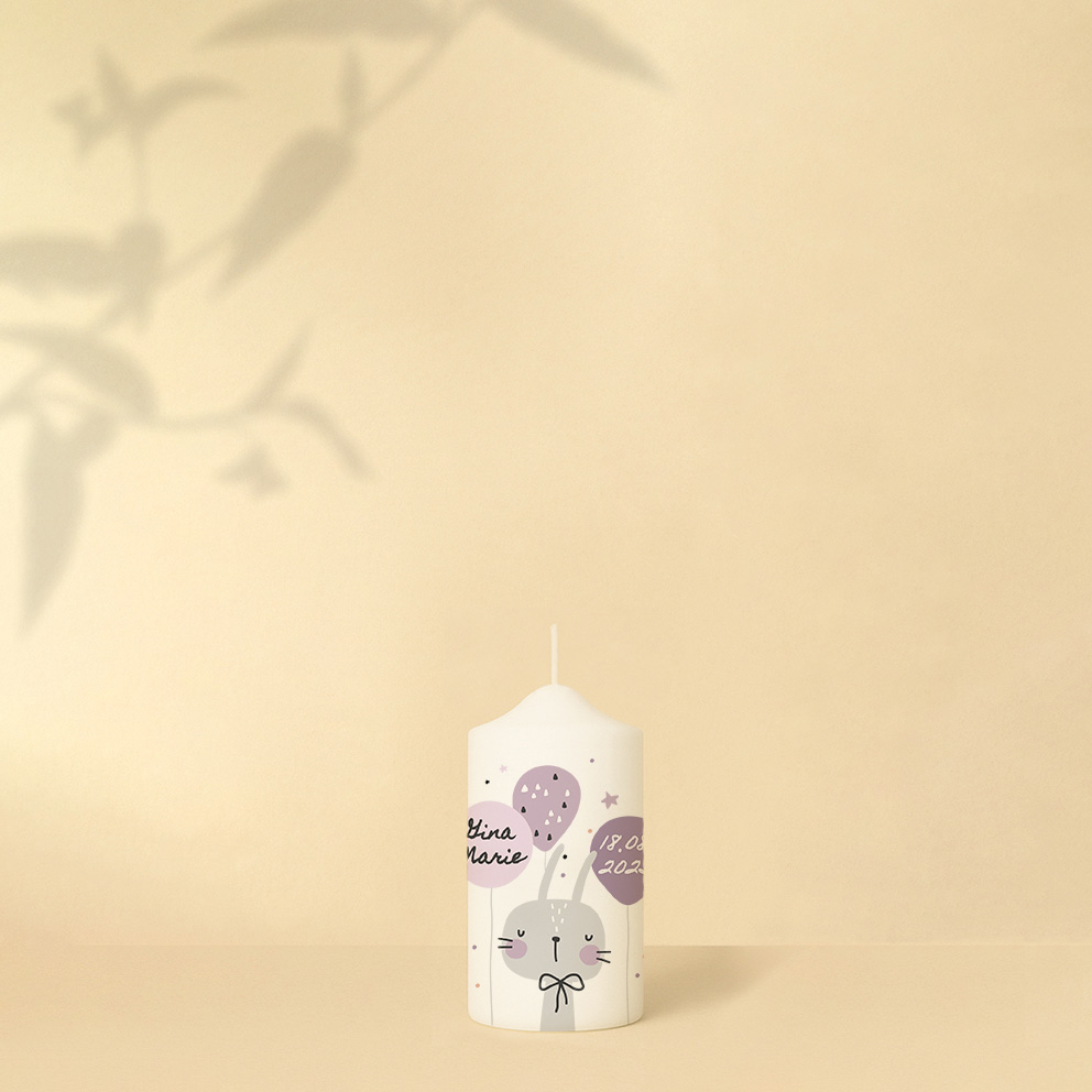 Personalisierte Geburtstagskerze mit Hase, Luftballons und Sternen in zarten Rosa- und Lilatönen oder als zweite in Orangetönen – Variante verspielt und zart zugleich.