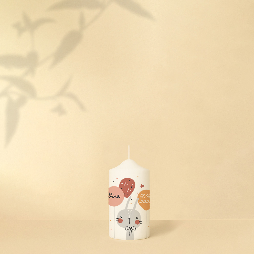 Personalisierte Geburtstagskerze mit Hase, Luftballons und Sternen in zarten Rosa- und Lilatönen oder als zweite in Orangetönen – Variante verspielt und zart zugleich.